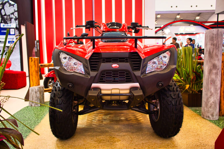 Začiatočník stojí pri štvorkolke a zvažuje jej výber, pripravuje sa na svoju prvú jazdu v teréne.